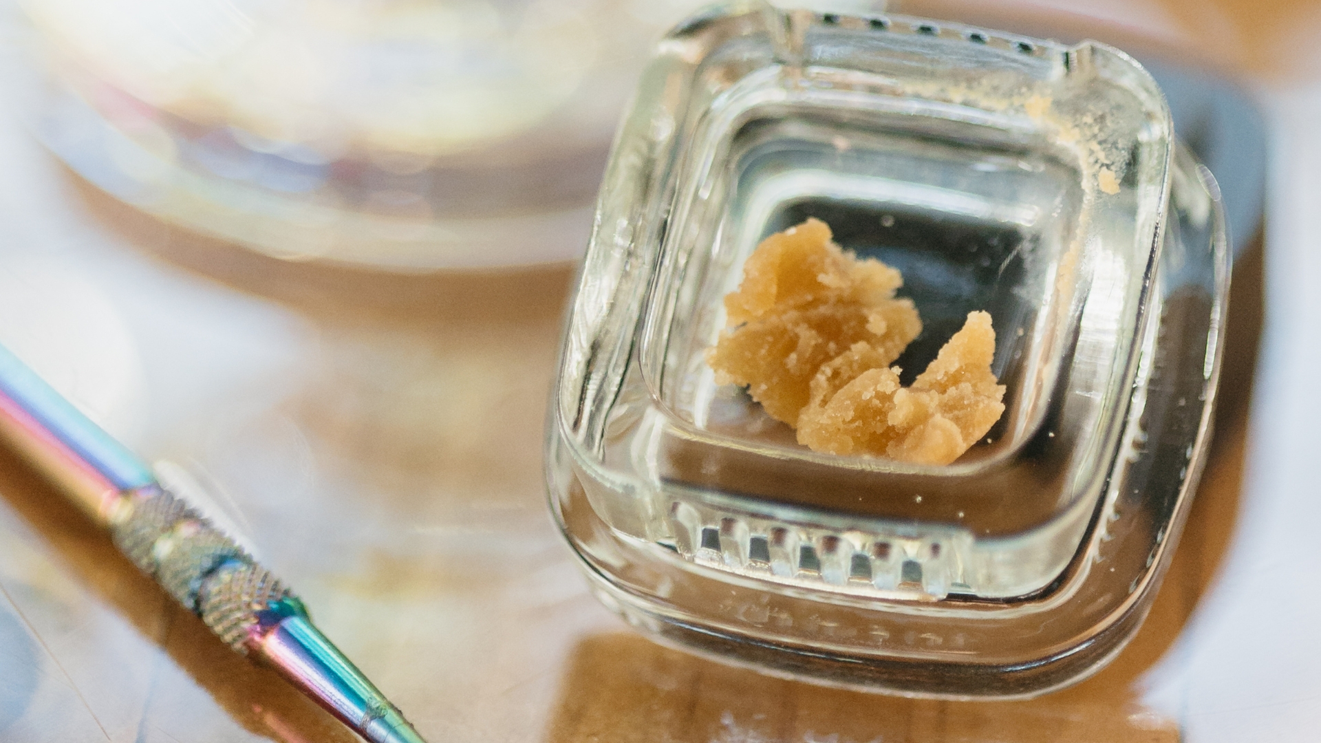 Jar of hash rosin cannabis concentrate showcasing its solventless texture and golden appearance